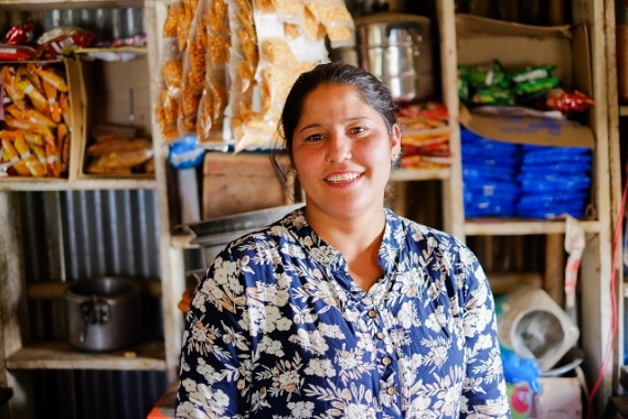 Sumitra smiling in her small business.