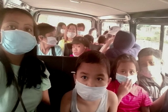 SOS children wear protective masks as they evacuate.