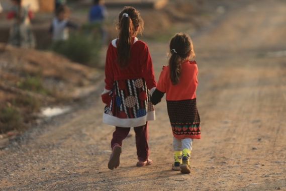 Two young refugee girls holding hands