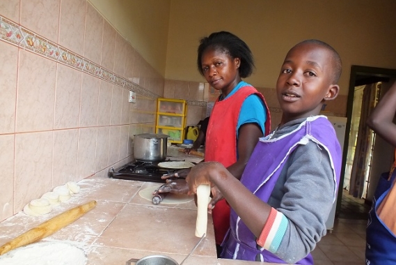 Rodah and her SOS Children baking in the kitchen.