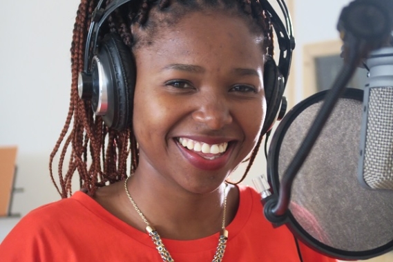 Tumi smiling in the recording studio.