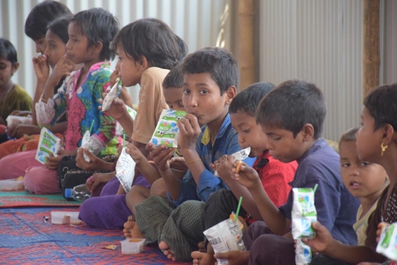 Children eating snack, emergency response program in Bangladesh