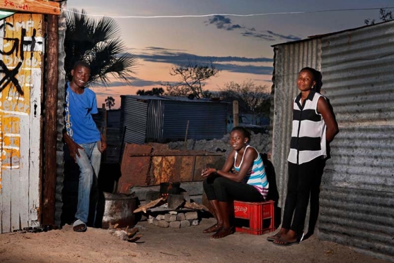 Young mother with siblings at home in Ondangwa, Namibia.