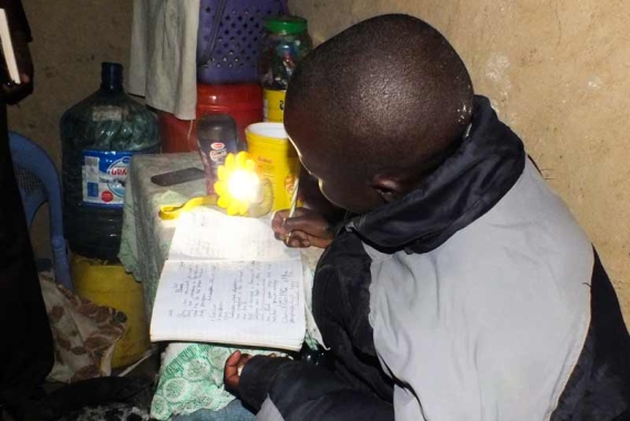You girl doing homework at night using a sun lamp
