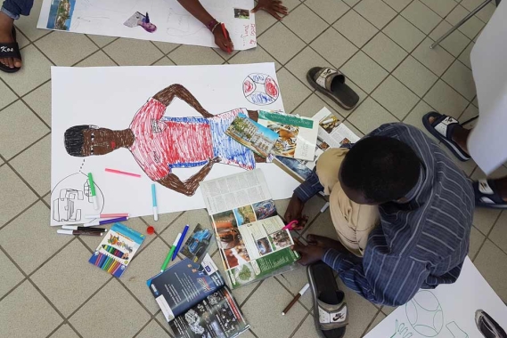 Refugee boy drawing a picture of himself