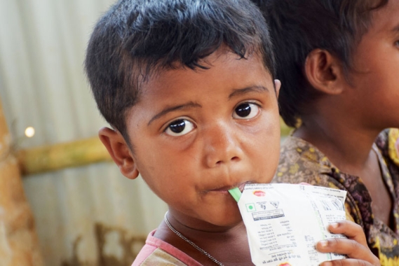 Rohingya child refugee eating a food ration