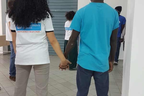 SOS worker holding the hand of a youth refugee in Italy