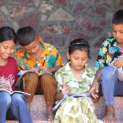 children in Cambodia doing homework together.