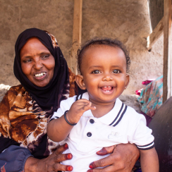 mother holding her young child in Hargeisa, Somaliland, both are smiling.
