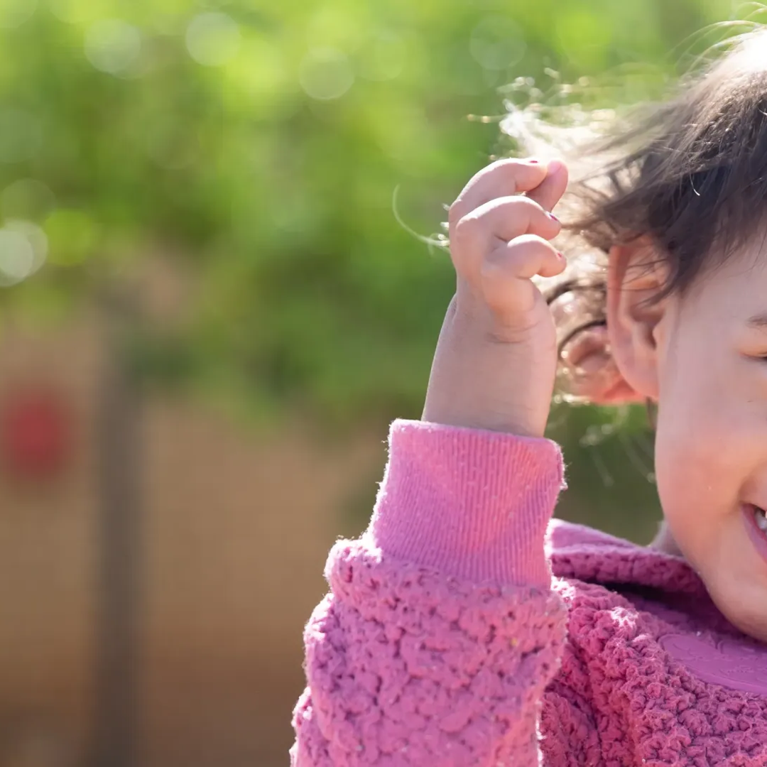 A young girl smiling looking into the camera