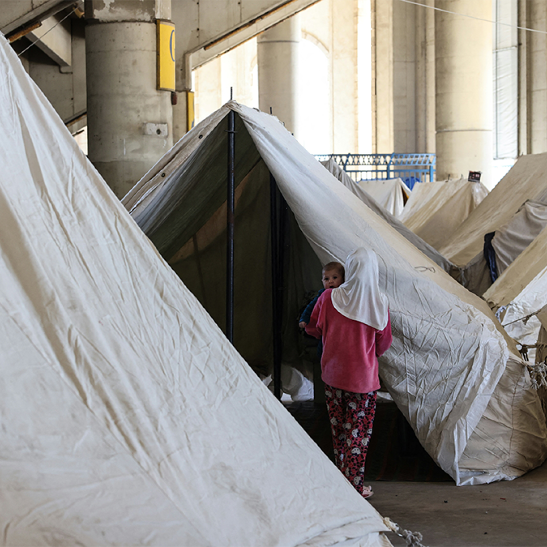 A woman holding her child in a refugee camp