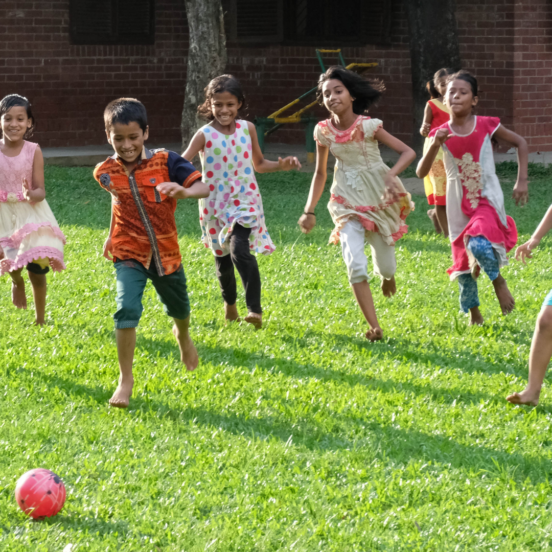 A group of young children playing soccer in Bangladesh.