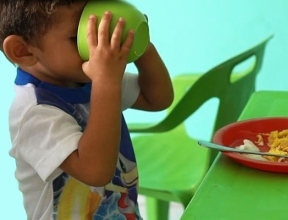 Enfant savourant un repas nutritif dans un espace SOS adapté aux enfants.