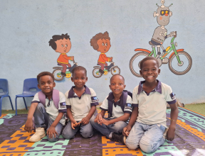 Four boys sitting together and smiling in Sudan