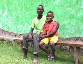 Father and son sitting together outside their home in Ethiopia, participants in the SOS Children’s Villages Family Strengthening Program.
