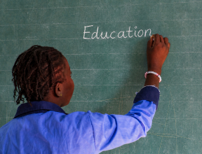 Student writing on a classroom chalkboard during an education activity in West Africa.