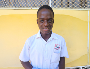 A young man in Jamaica looking at the camera smiling