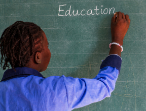 Student writing on a classroom chalkboard during an education activity in West Africa.