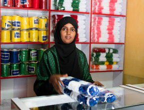 Farah stands inside her flower shop in Hargeisa, Somaliland, surrounded by colourful ribbon used to create handcrafted floral arrangements.