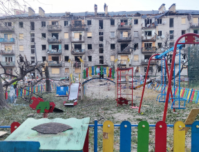 An empty children's playground stands in front of an apartment building damaged during the overnight attack in Kyiv.
