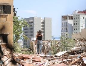 A mother and daughter walk through the debris of their apartment complex