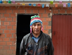 Secundino standing in front of his home.