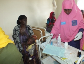 A nurse treating a mother at an SOS medical centre.