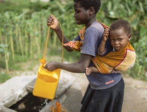 Tia getting water with her younger brother.