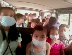 SOS children wear protective masks as they evacuate.