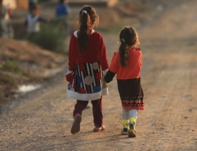 Two young refugee girls holding hands