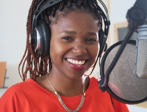 Tumi smiling in the recording studio.