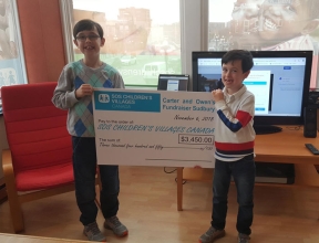 Young brothers presenting their fundraising cheque