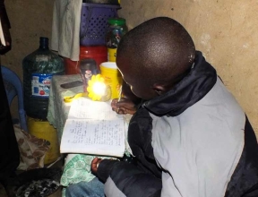 You girl doing homework at night using a sun lamp