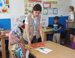 The topic of the unit today is “Herbarium”. Children are creating a page with dried flowers. Educator Jelena Zdravković talks to a girl from Afghanistan how to prepare a nice picture that she can give to her mother as a present.