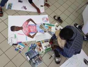 Refugee boy drawing a picture of himself