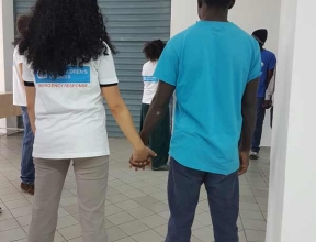 SOS worker holding the hand of a youth refugee in Italy