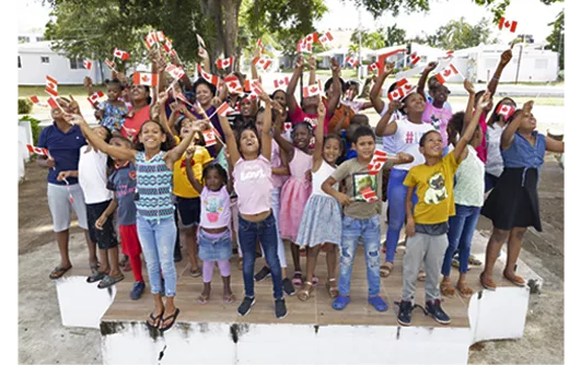 Children in the Dominican Republic, each holding a flag.