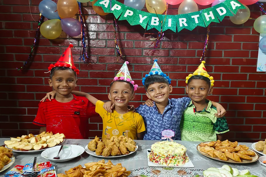 Four young boys celebrating at a birthday party