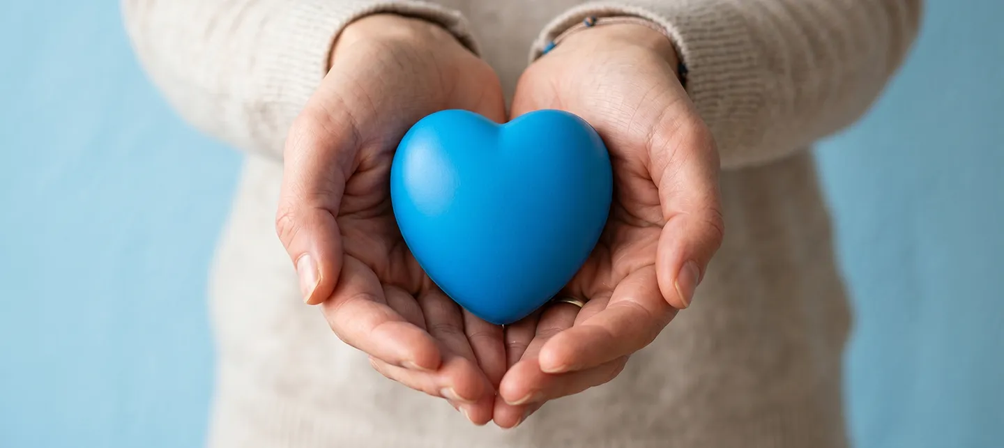 Two hands holding a blue heart
