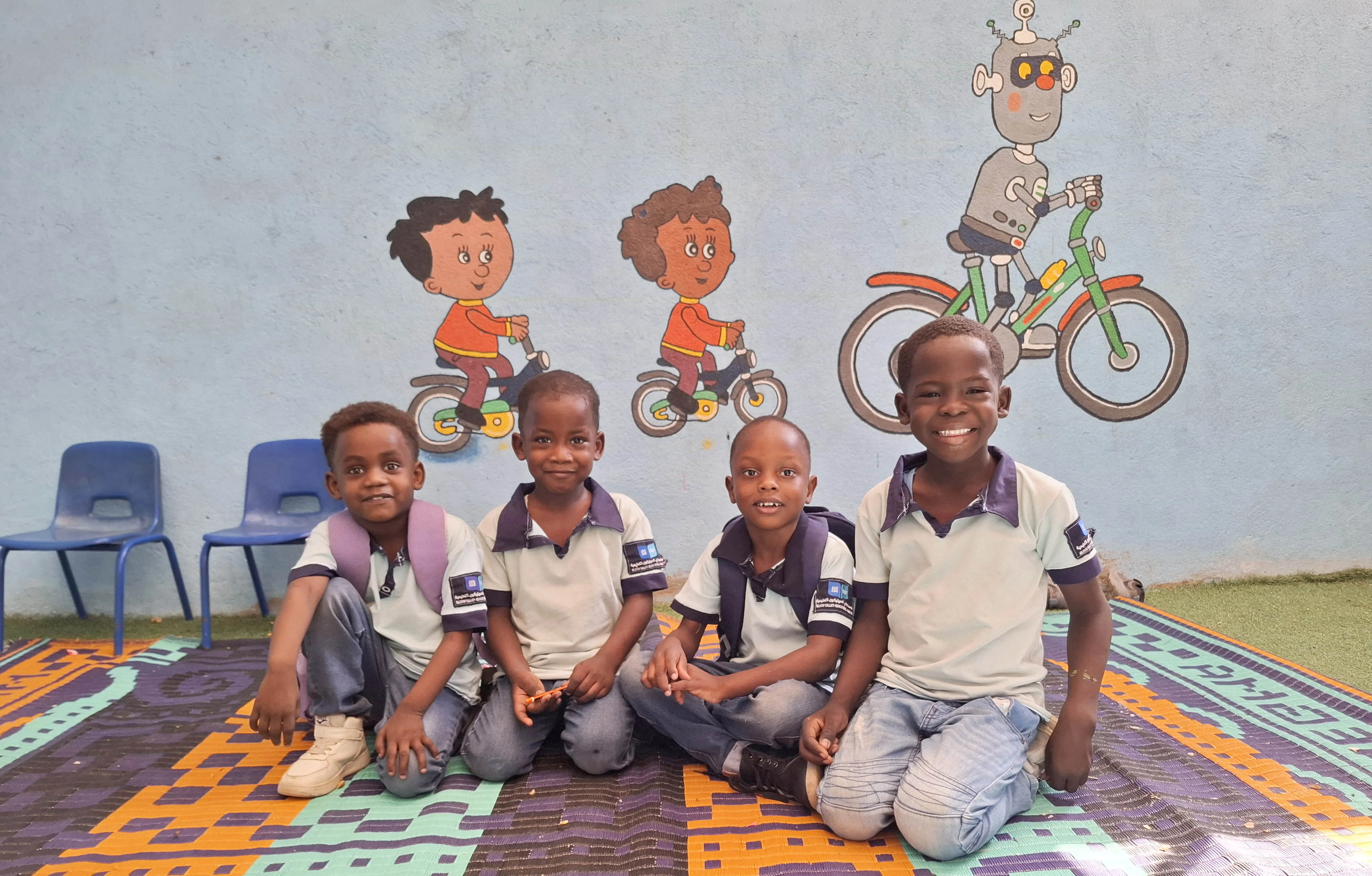 Four boys sitting together and smiling in Sudan