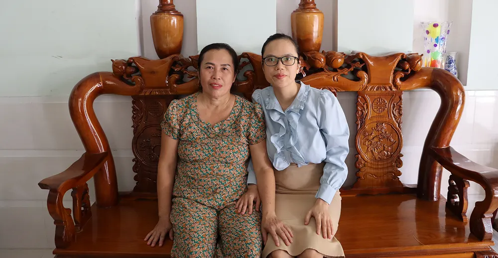 Two woman sitting together on a bench in Vietnam