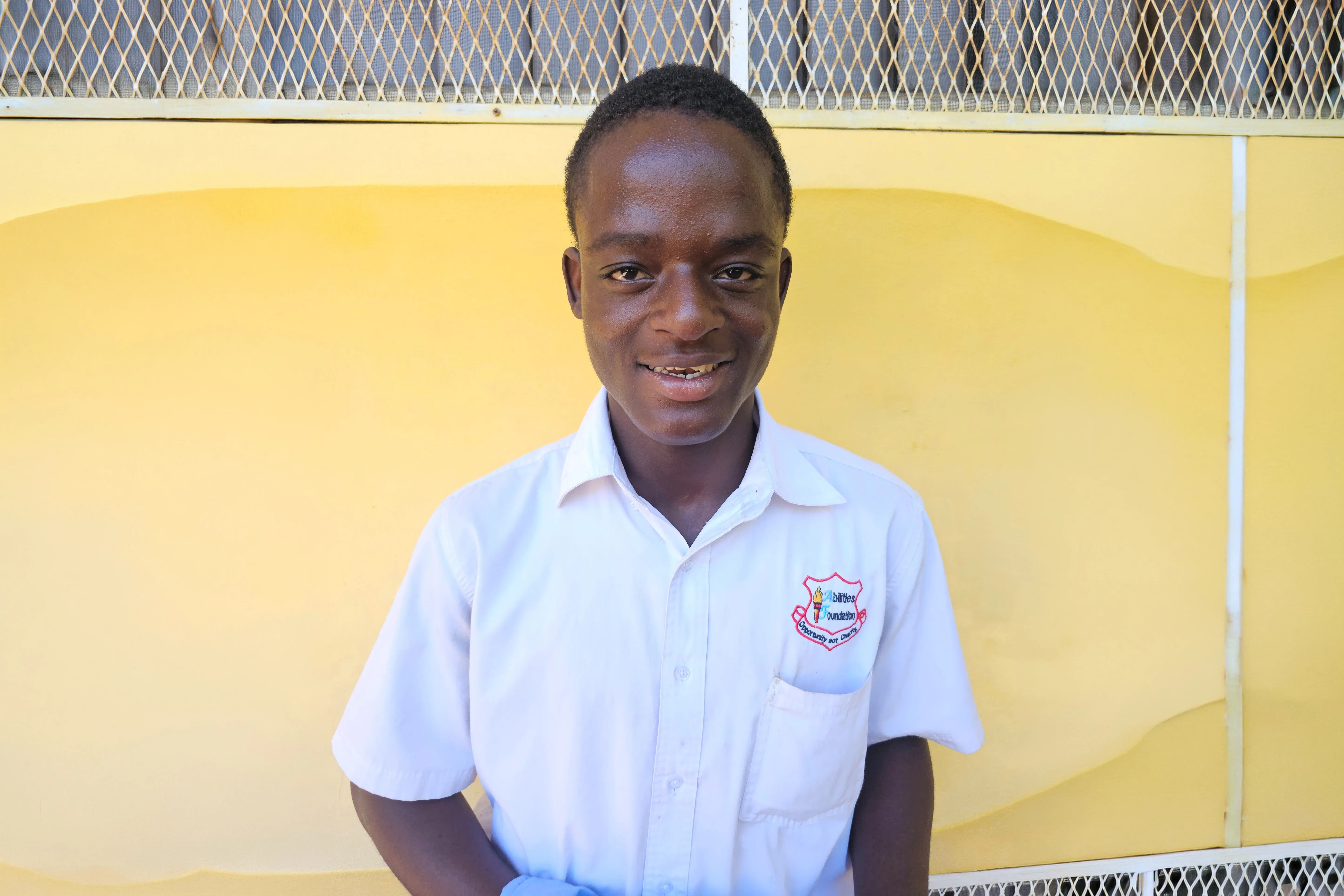 A young man in Jamaica looking at the camera smiling