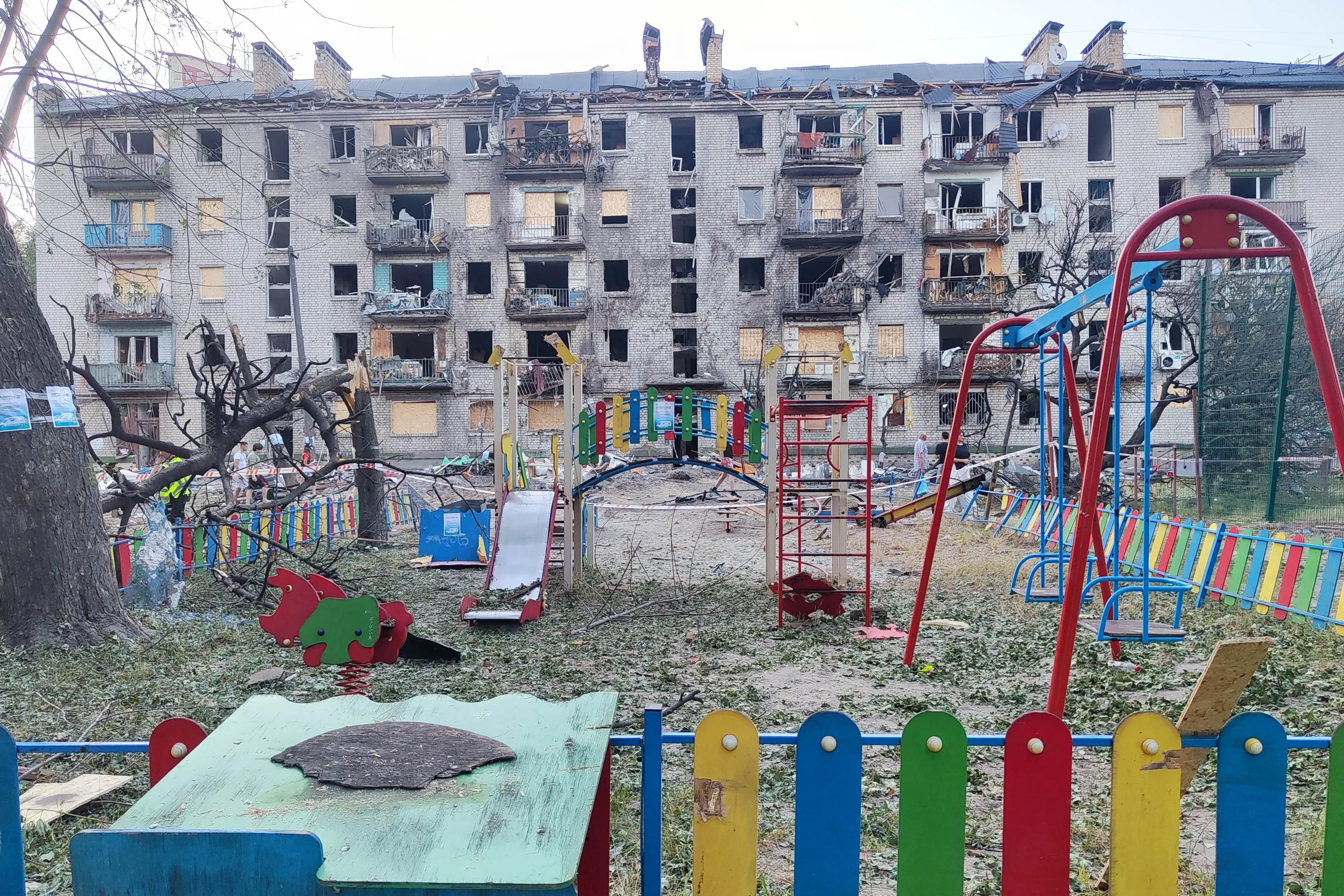 An empty children's playground stands in front of an apartment building damaged during the overnight attack in Kyiv.