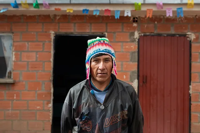Secundino standing in front of his home.