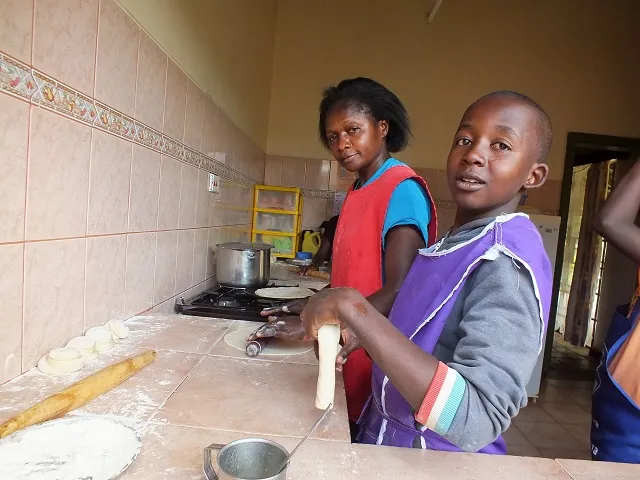 Rodah and her SOS Children baking in the kitchen.