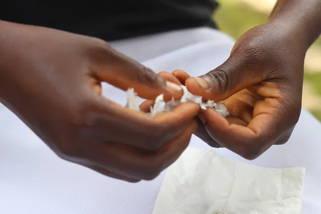 Close up of Solange's* hands breaking bread
