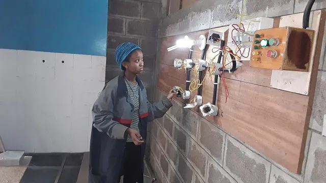 Zala turning the lights on with her newly acquired elctrical skills.