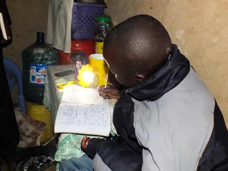 You girl doing homework at night using a sun lamp