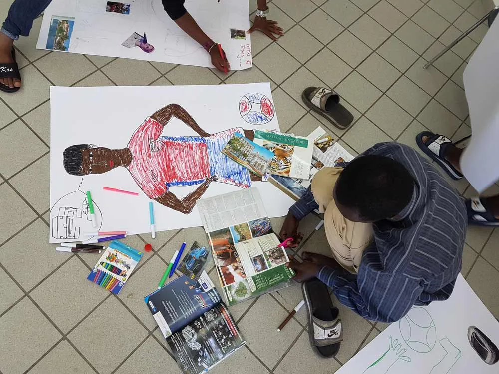 Refugee boy drawing a picture of himself