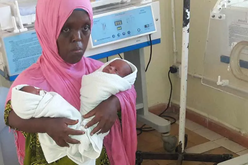 Mother holding her newborn twins